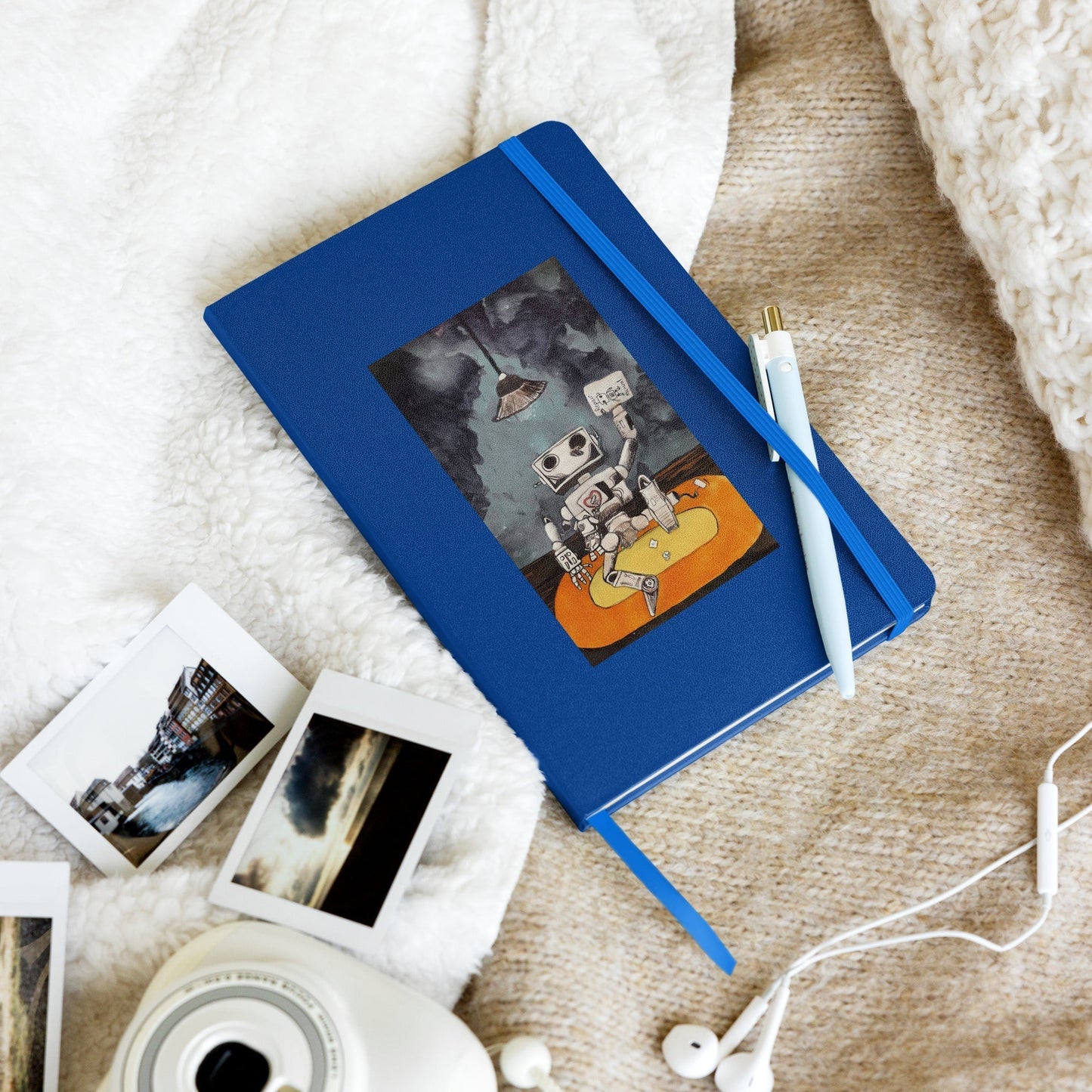 Hardcover notebook with elastic closure and ribbon marker on soft fabric background.